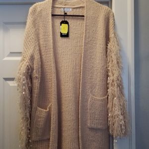 Brand new sweater cardigan with frilly sleeves.